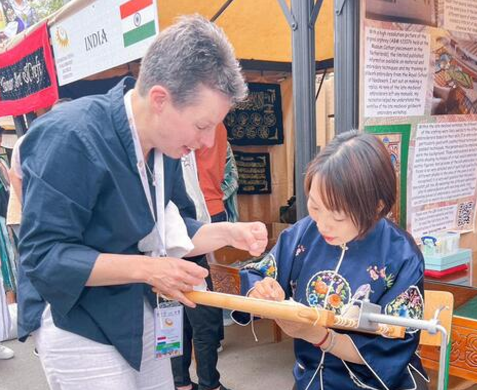 Dr Jessica Grimm teaching a gold embroiderer from South Korea how to stitch the medieval way at the International Festival of Gold Embroidery, Bukhara, Uzbekistan