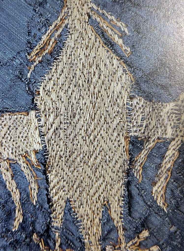 Detail goldwork embroidery with stitched guidelines.