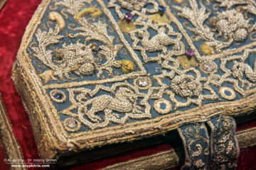 Pearl Embroidery - a blue pearl-embroidered mitre on display in a museum.