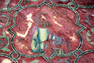 Italian embroidery - A large red cope laying flat in a museum display case.