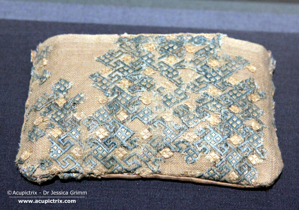 Medieval Embroidery Pattern - damaged colourful embroidery in display case