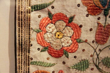 Linen Vestments Tyrol - an embroidered chasuble displayed in a glass case
