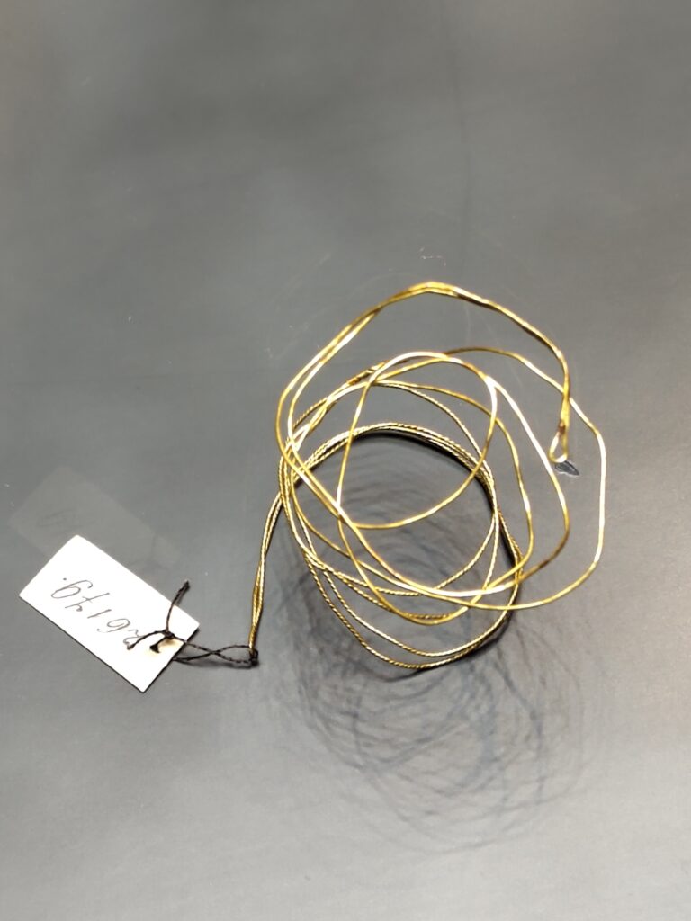 Gold threads - a coil of gold thread with a label