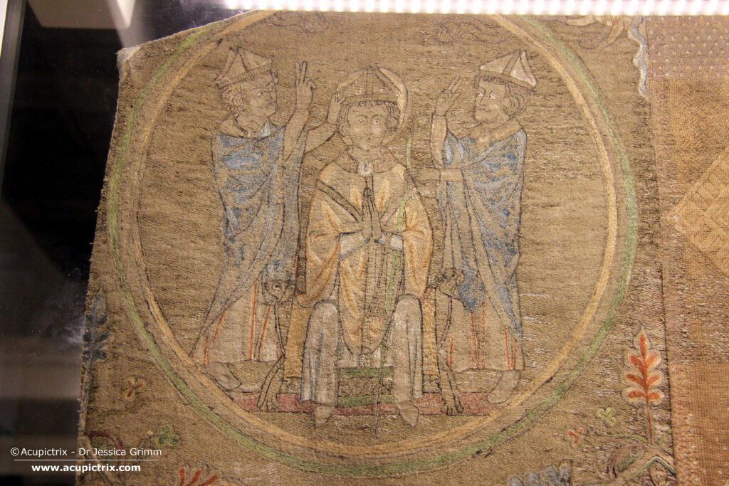 Opus anglicanum - embroidered scene with two men blessing a bishop