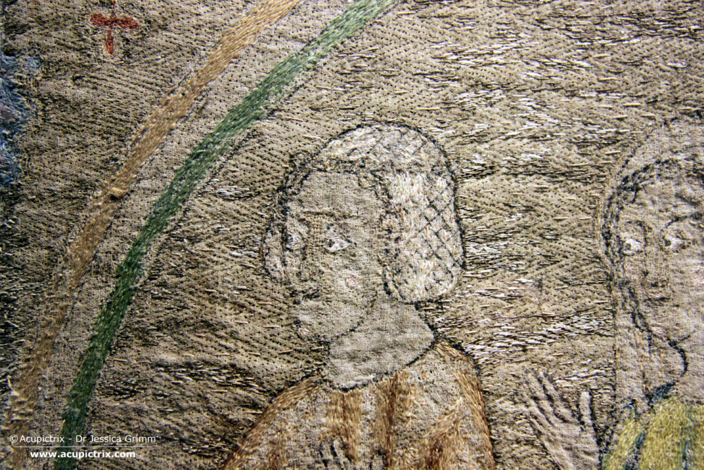 Opus anglicanum - detail of multi coloured embroidery showing a female head