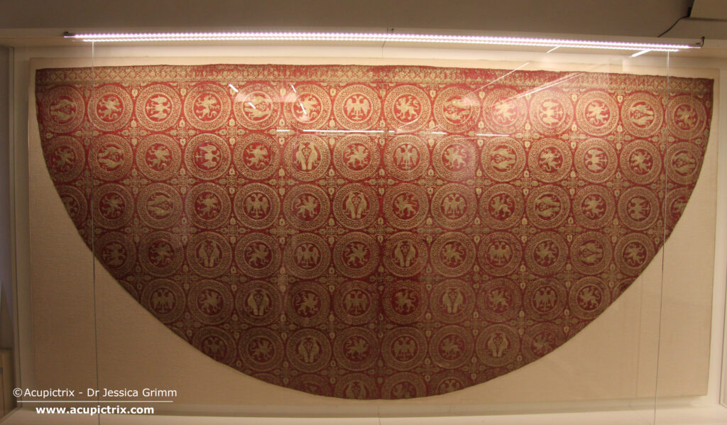 Opus cyprense - red cope with goldwork embroidery in a display case