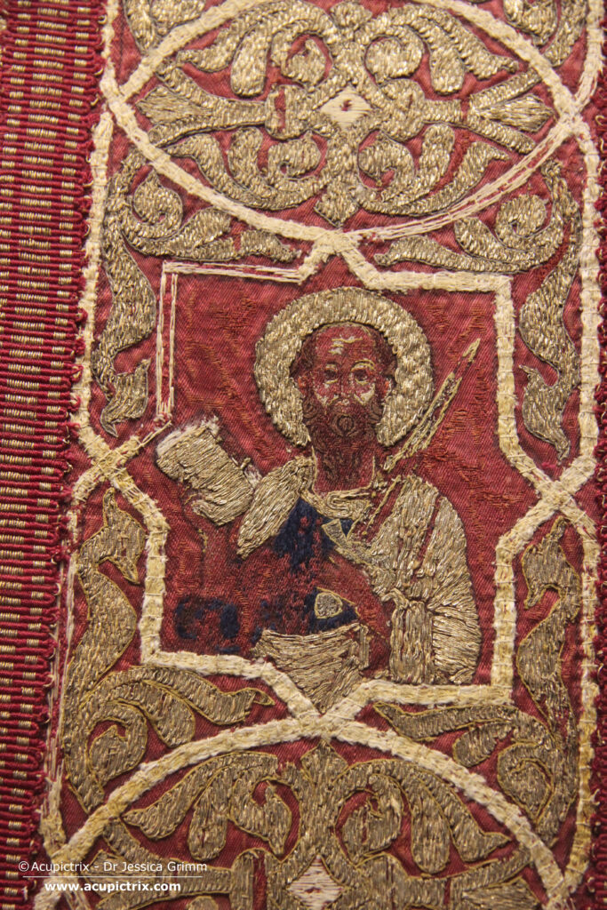 Opus cyprense - detail of goldwork embroidery on red silk featuring a bearded man with a sword