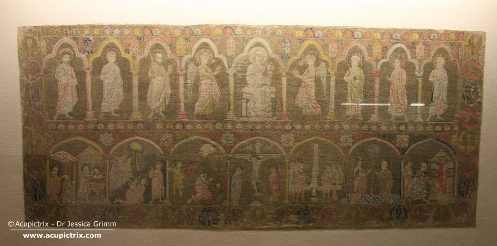 Opus romanum - multi coloured embroidered rectangular cloth in a display case